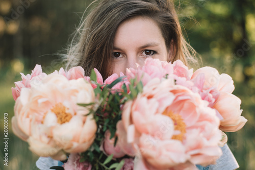 Florist woman looking over peony flowers