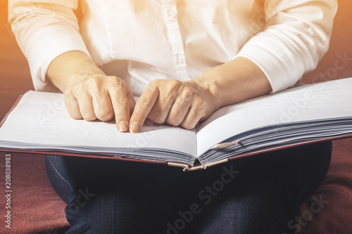 Blind woman read book written in Braille