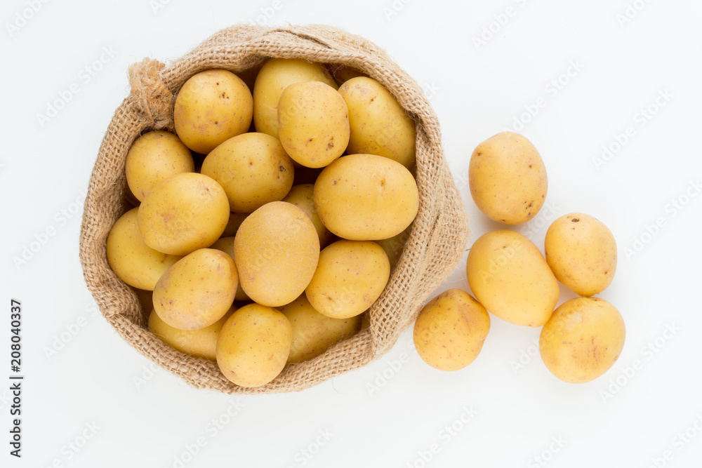 Sack of fresh raw potatoes on wooden background, top view Sack of fresh raw potatoes on wooden background, top view