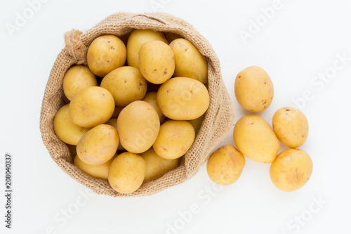 Sack of fresh raw potatoes on wooden background  top view