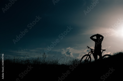 Cyclist with ebike rests and looks the landscape