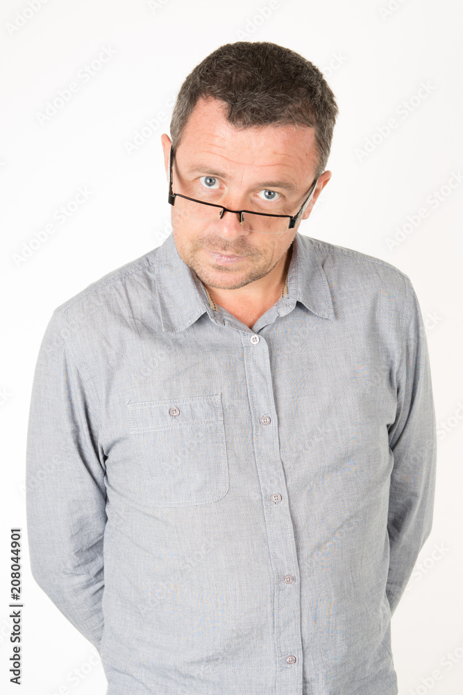 Close up portrait of handsome mid man with glasses looking at camera standing against a white wall Close up portrait of handsome mid man with glasses looking at camera standing against a white wall