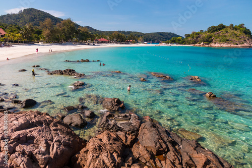 Beautiful scenic view of the rocky part of Long Beach (Pasir Panjang) on Redang Island in Malaysia. Tourists enjoying their leisure time with swimming, snorkeling & walking on the white powdery sand.  photo