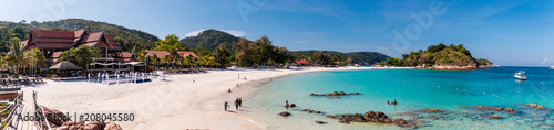 Beautiful panoramic view of Long Beach (Pasir Panjang) on Redang Island in Terengganu, Malaysia. Tourists enjoying their leisure time along the white powdery sand beach and crystal clear blue water.