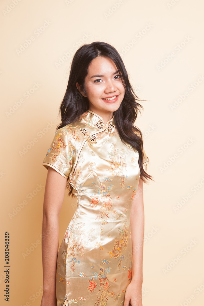 Portrait of Asian girl in golden chinese cheongsam dress Portrait of Asian girl in golden chinese cheongsam dress