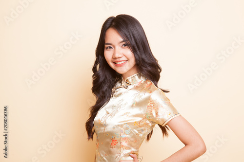 Portrait of Asian girl in golden chinese cheongsam dress photo