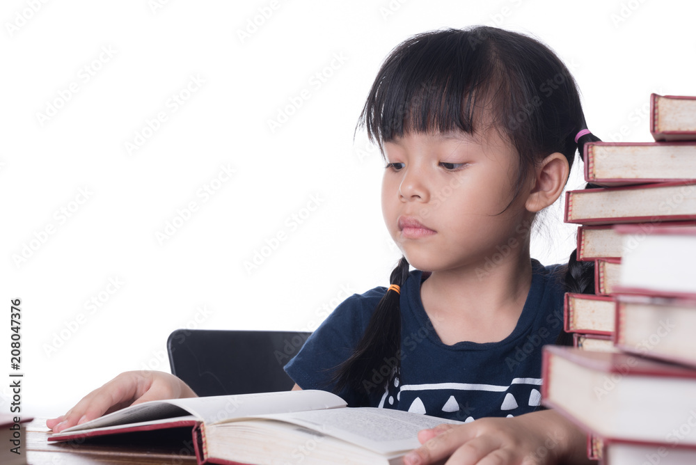 The girl is reading a book at the table.