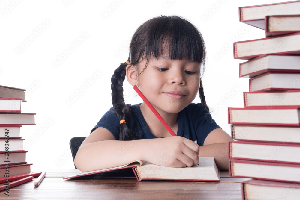 The girl is reading a book at the table. The girl is reading a book at the table.