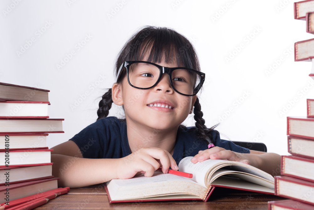 The girl is reading a book at the table. The girl is reading a book at the table.