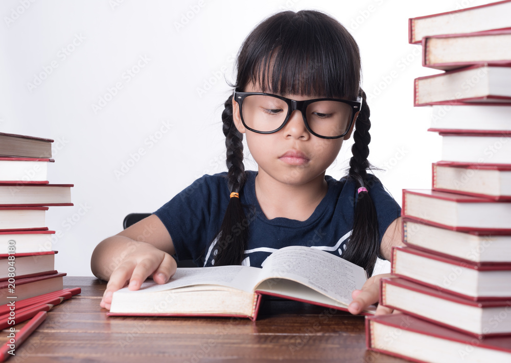 The girl is reading a book at the table. The girl is reading a book at the table.