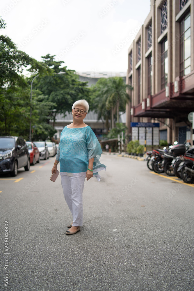 asian old lady walking crossing street