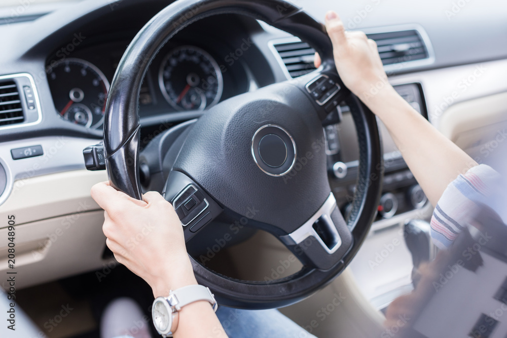 partial view of woman with hands on steering wheel driving car