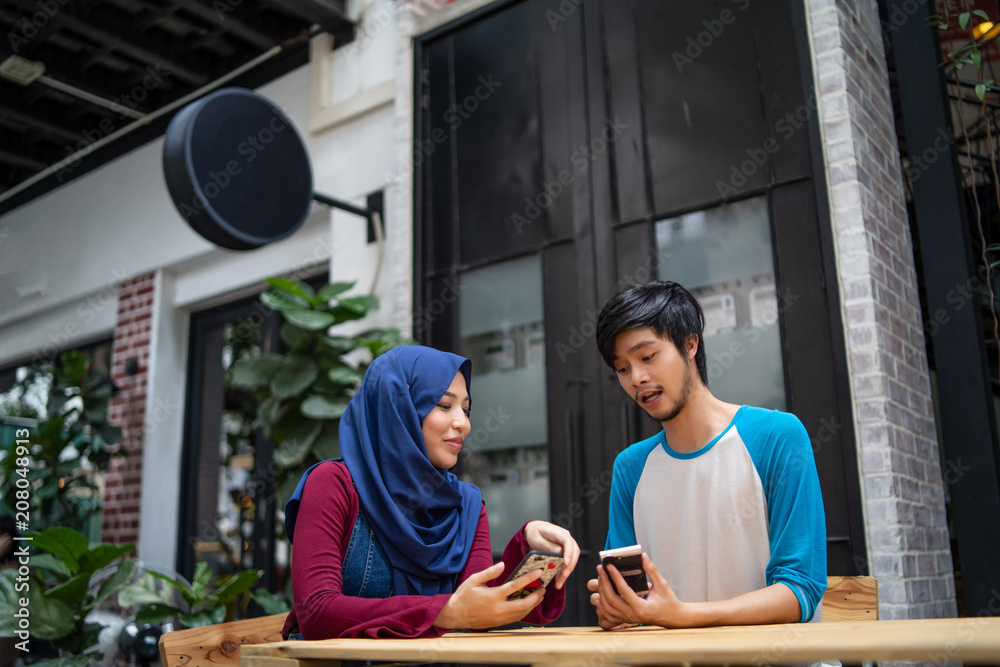 Fototapeta premium a muslim married couple in a cafe with a laptop
