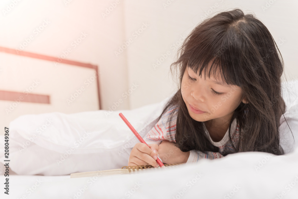 little girl lying on the bed and reading a book little girl lying on the bed and reading a book