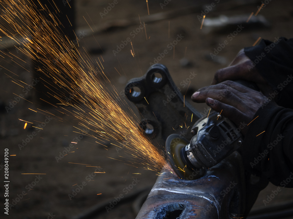  Man grinds a steel piece