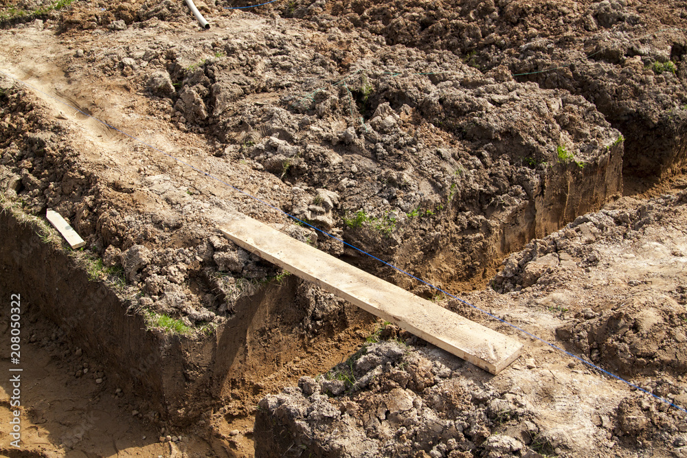 angle of the trench dug by hand under the Foundation or for laying drainage and lines drawn from a rope for evenness angle of the trench dug by hand under the Foundation or for laying drainage and lines drawn from a rope for evenness