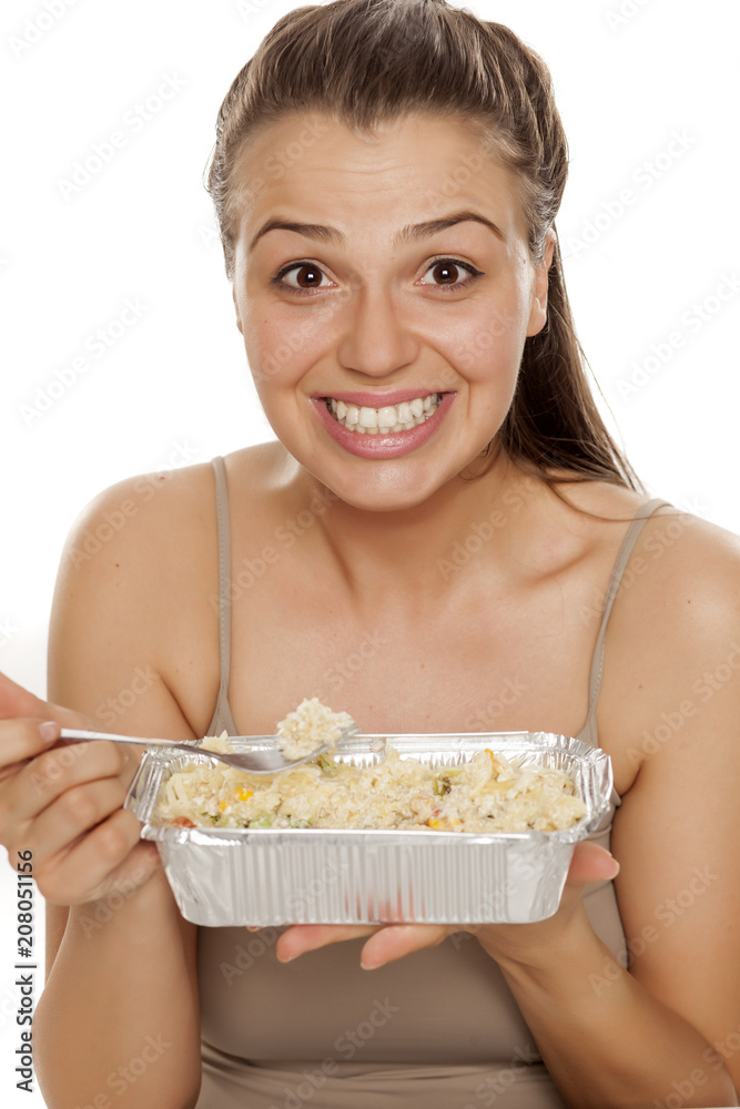 A young beautiful woman eating food to take on white background A young beautiful woman eating food to take on white background