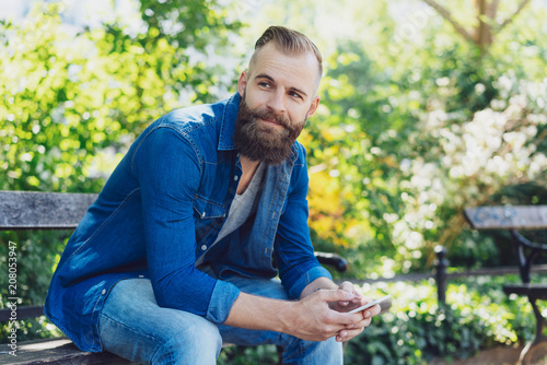Attractive bearded man siting on a park bench