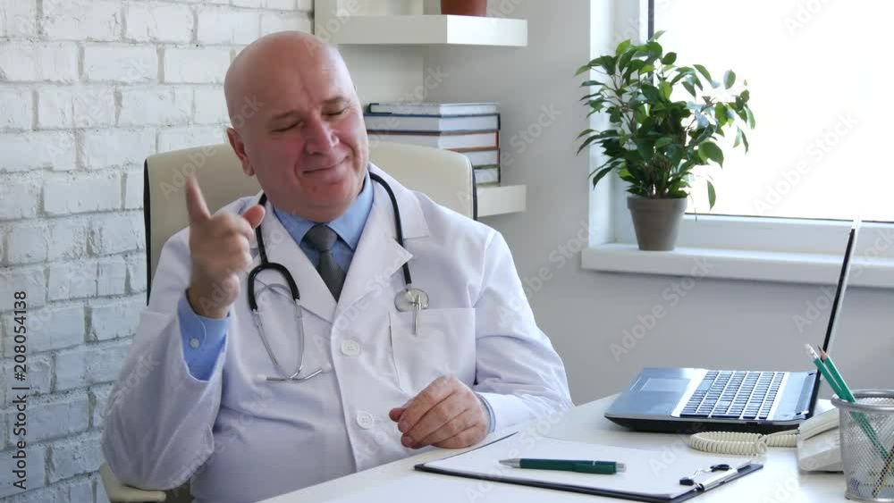 Happy and Pleased Doctor Smile Looking to Camera Warning With a Finger Sign Happy and Pleased Doctor Smile Looking to Camera Warning With a Finger Sign
