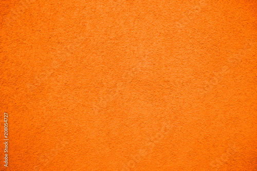 Vivid bright orange color coarse facade wall as an empty rustic texture background.