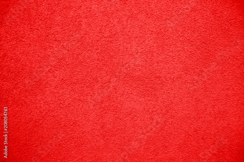 Vivid bright red color coarse facade wall as an empty rustic texture background.