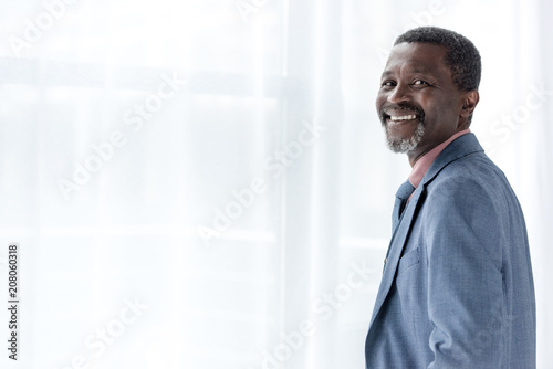 mature cheerful african american man in blue jacket