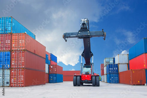 Reach stacker is working in the container depot as in logistics warehouse background. photo