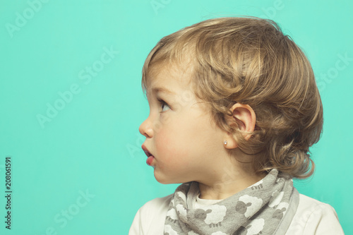 Lovely little girl on a blue background .Little girl in profile