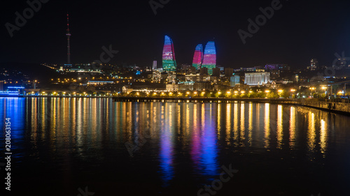 Fototapeta Naklejka Na Ścianę i Meble -  Baku night cityscape with flaming towers and reflections in the Caspian sea bay