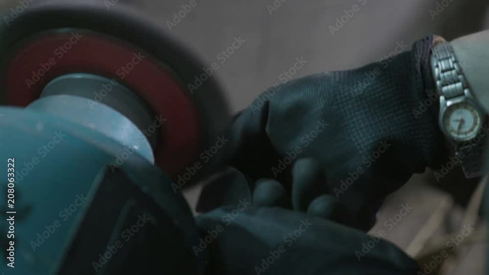 Close up of blacksmith woman hands polishing metal using a professional wheel in an industrial factory workshop Close up of blacksmith woman hands polishing metal using a professional wheel in an industrial factory workshop