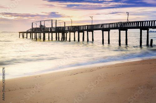 The old bridge into the sea on the beach.