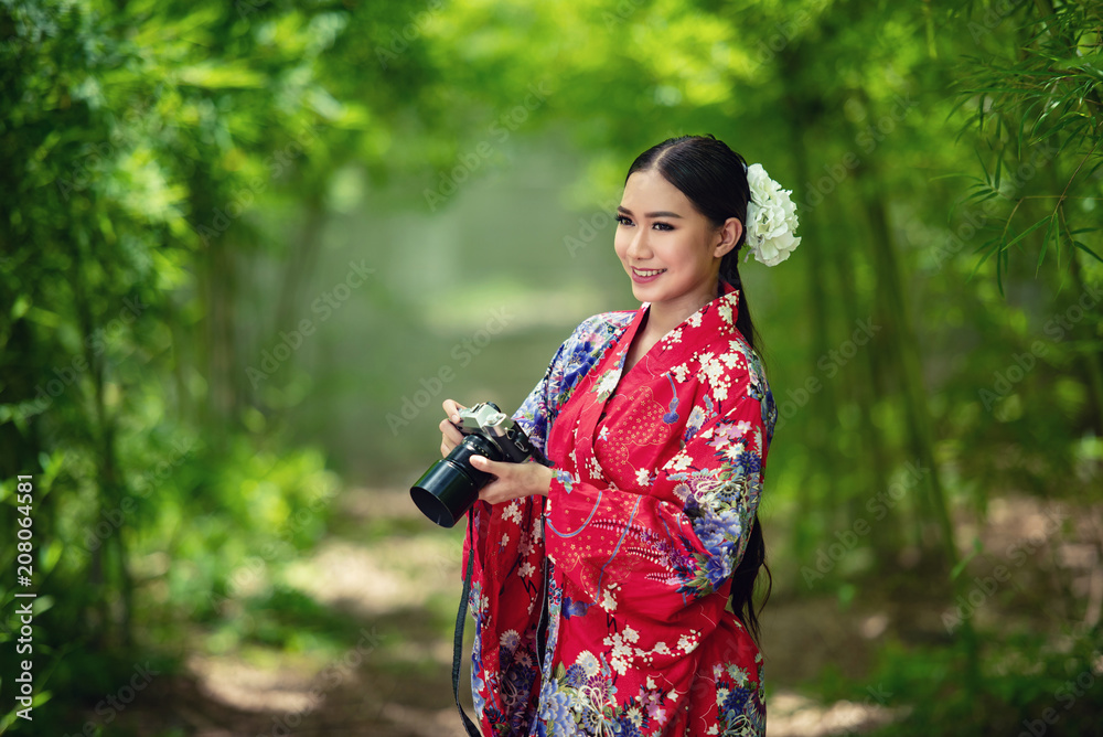 Japanese woman wearing a kimono is shooting with a camera. Japanese woman wearing a kimono is shooting with a camera.