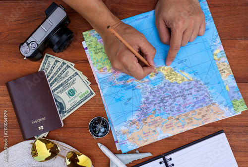 Young man planning vacation trip with map. Top view. Pointing to travel on map.