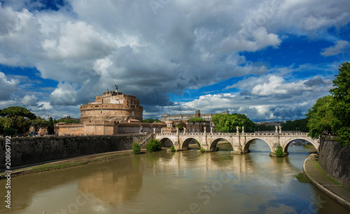 Panoramic view of River Tiber with the Holy Angel Castle and Bridge under a cloudy sky in Rome