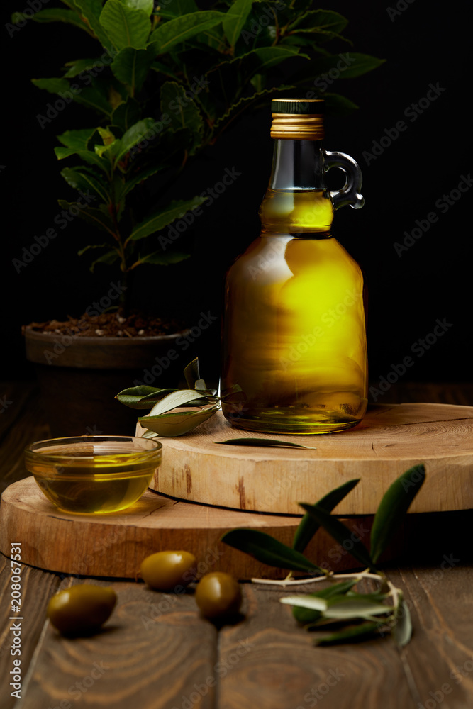 Naklejka olive oil in bottle and bowl on wooden boards