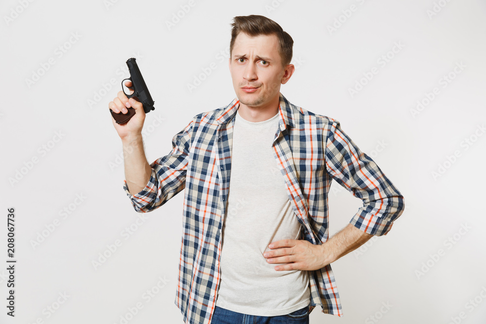 Shocked sad upset young man with gun in hand isolated on white background.  Male with handgun, no shooting symbol. Stop violence, weapons in school  control, no killing people children, problem concept. Photos |