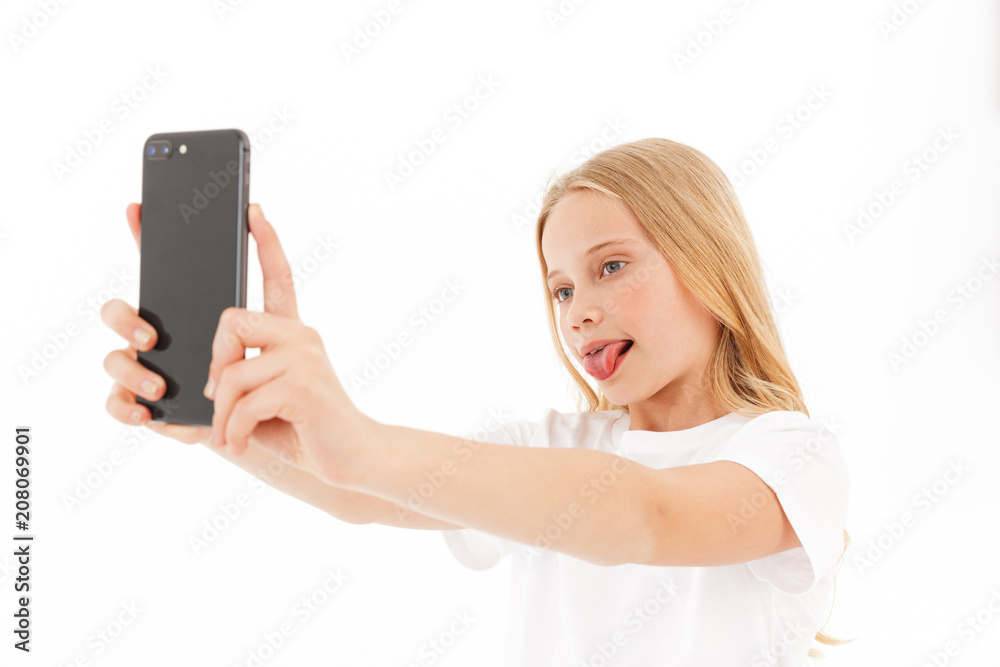 Playful blonde girl in casual clothes making selfie on smartphone Playful blonde girl in casual clothes making selfie on smartphone