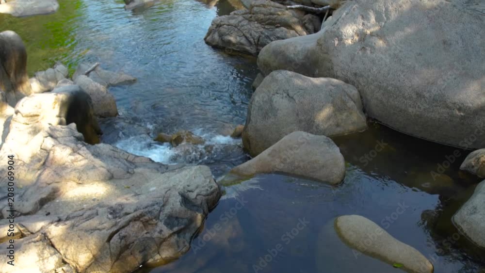 Large stones and rocks in mountain river. Mountain waterfall and stony river in tropical forest. Rapid river flow between big stone creating waterfall.