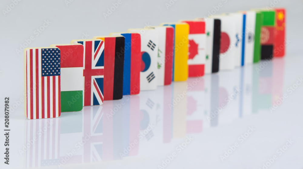 Fototapeta premium The domino effect with tiles of flags of different countries of the world. conceptual photo, political games. Studio shooting