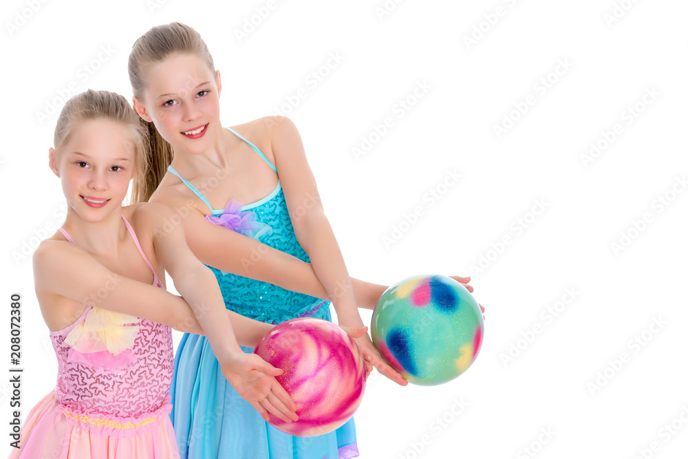 Girls gymnasts perform exercises with the ball. Girls gymnasts perform exercises with the ball.