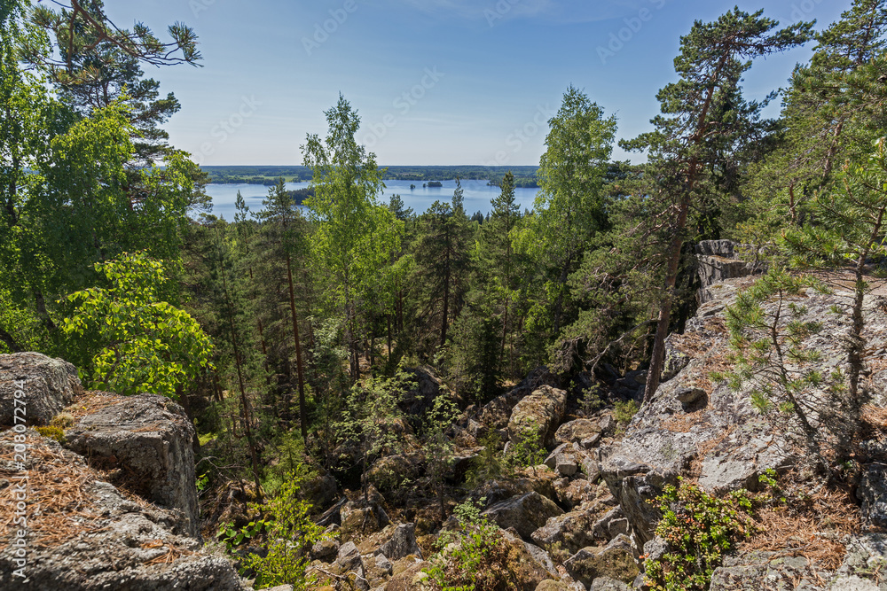 Lake, lush forest and rocky hill viewed from the rocky hilltop of Pirunvuori (