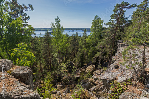 Lake, lush forest and rocky hill viewed from the rocky hilltop of Pirunvuori ("Devil's Mountain") on a sunny day in the summertime in Sastamala, Southern Finland.