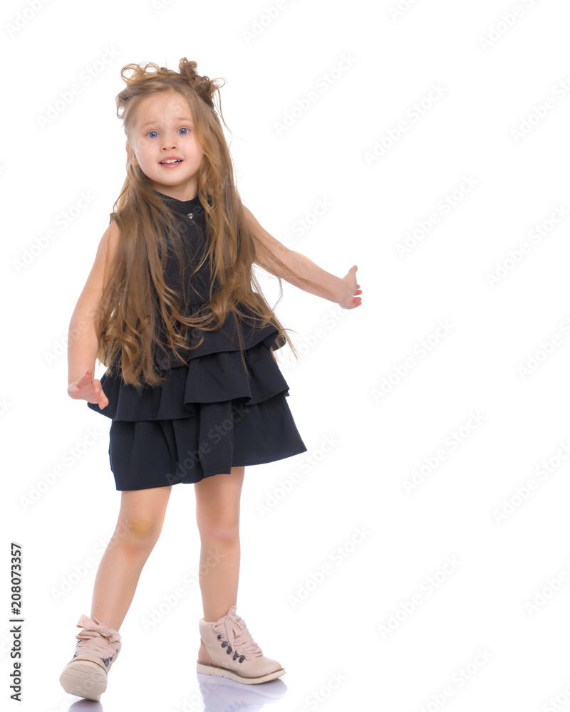 Fototapeta premium A cheerful little girl is dancing.