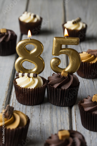 Number 85 celebration birthday cupcakes on a wooden background