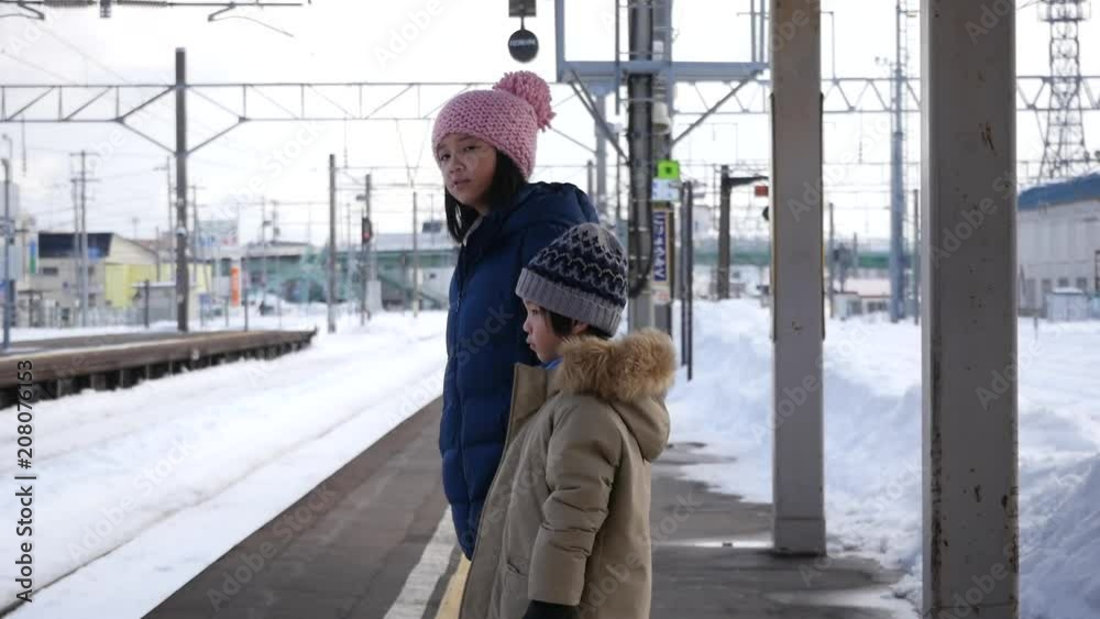 Asian children waiting express train on railway station platform,winter travel concept Asian children waiting express train on railway station platform,winter travel concept