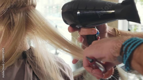 Wallpaper Mural Male hairdresser combing hair to blonde girl in beauty salon, close-up Torontodigital.ca