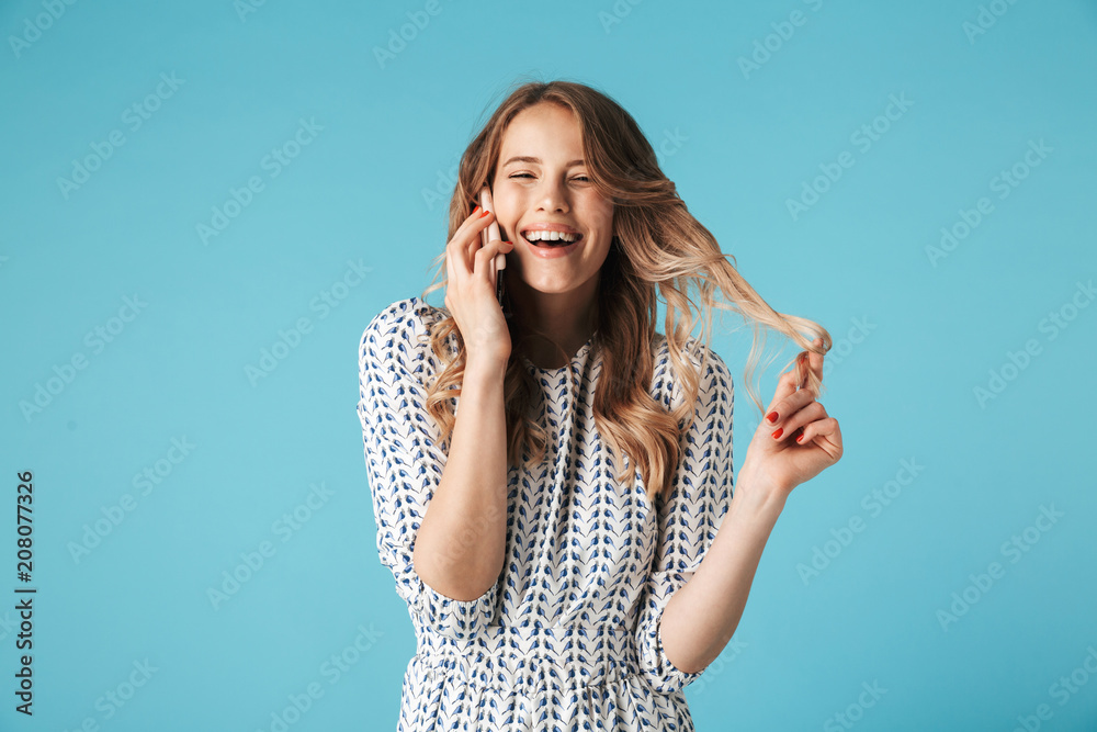 Laughing blonde woman in dress talking by smartphone Laughing blonde woman in dress talking by smartphone