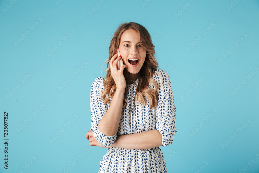 Surprised happy blonde woman in dress talking by smartphone Surprised happy blonde woman in dress talking by smartphone