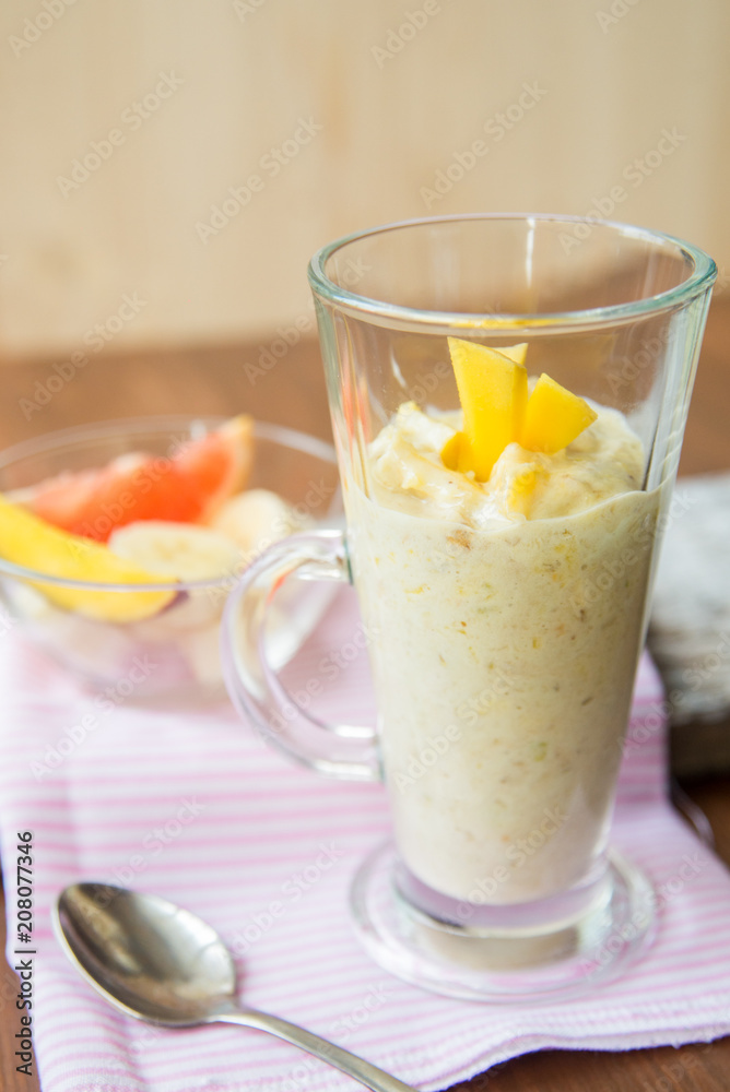 fresh smoothies in glass glass with banana, orange, mango, on wooden background. fresh smoothies in glass glass with banana, orange, mango, on wooden background.