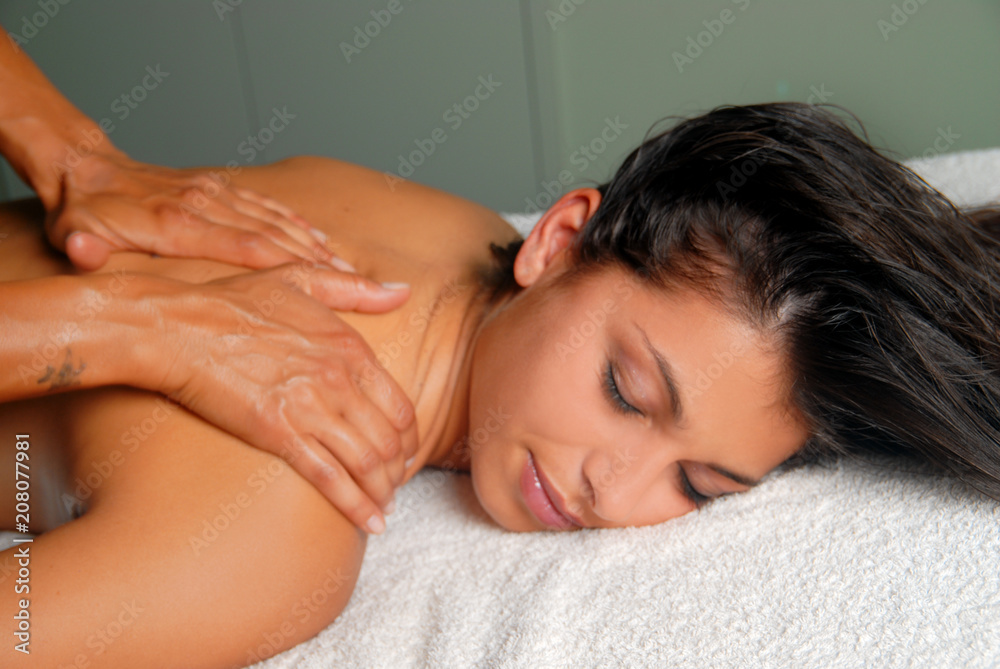 Young naked brunette getting a light massage on a spa bed Young naked brunette getting a light massage on a spa bed